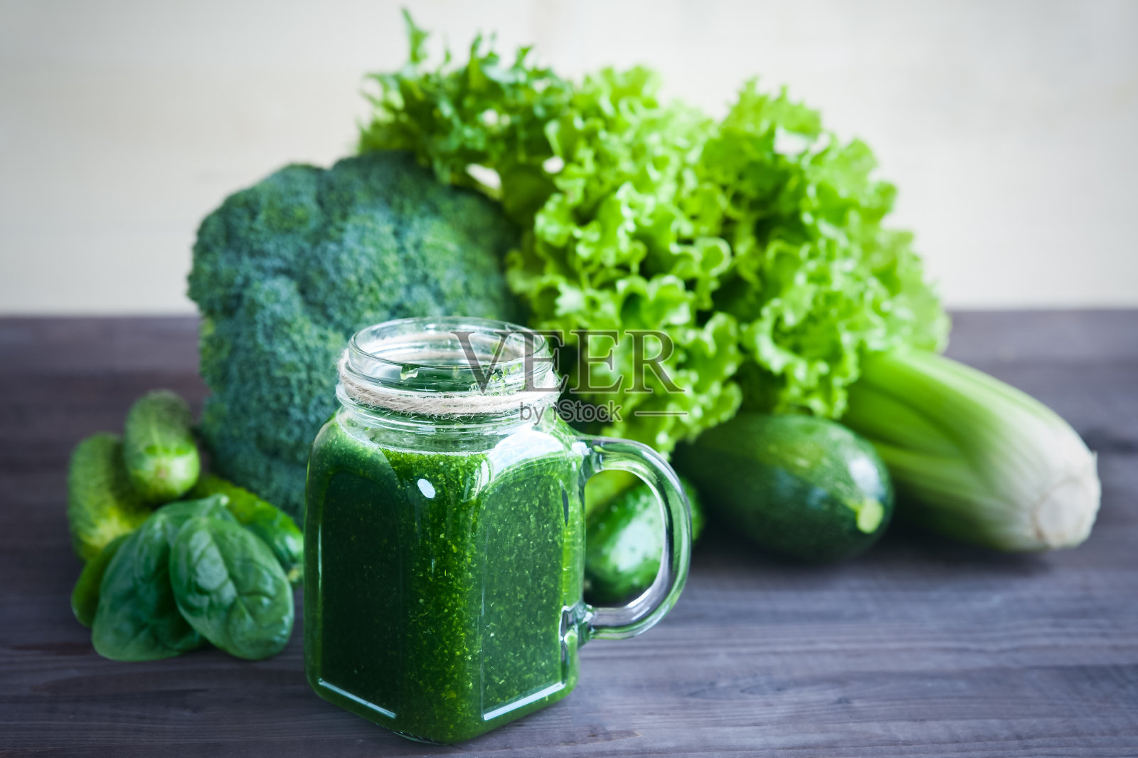 绿色蔬菜和蔬菜制成的冰沙。沙拉，花椰菜，菠菜，芹菜。玻璃和绿色的冰沙。从上面的观点照片摄影图片