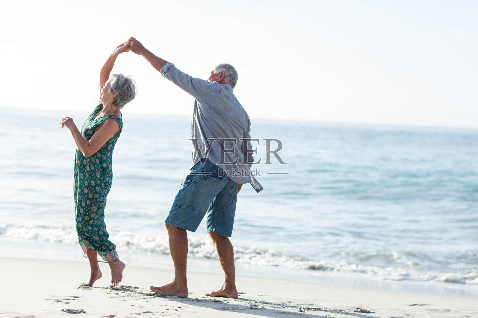 高年级情侣在海滩上跳舞照片摄影图片