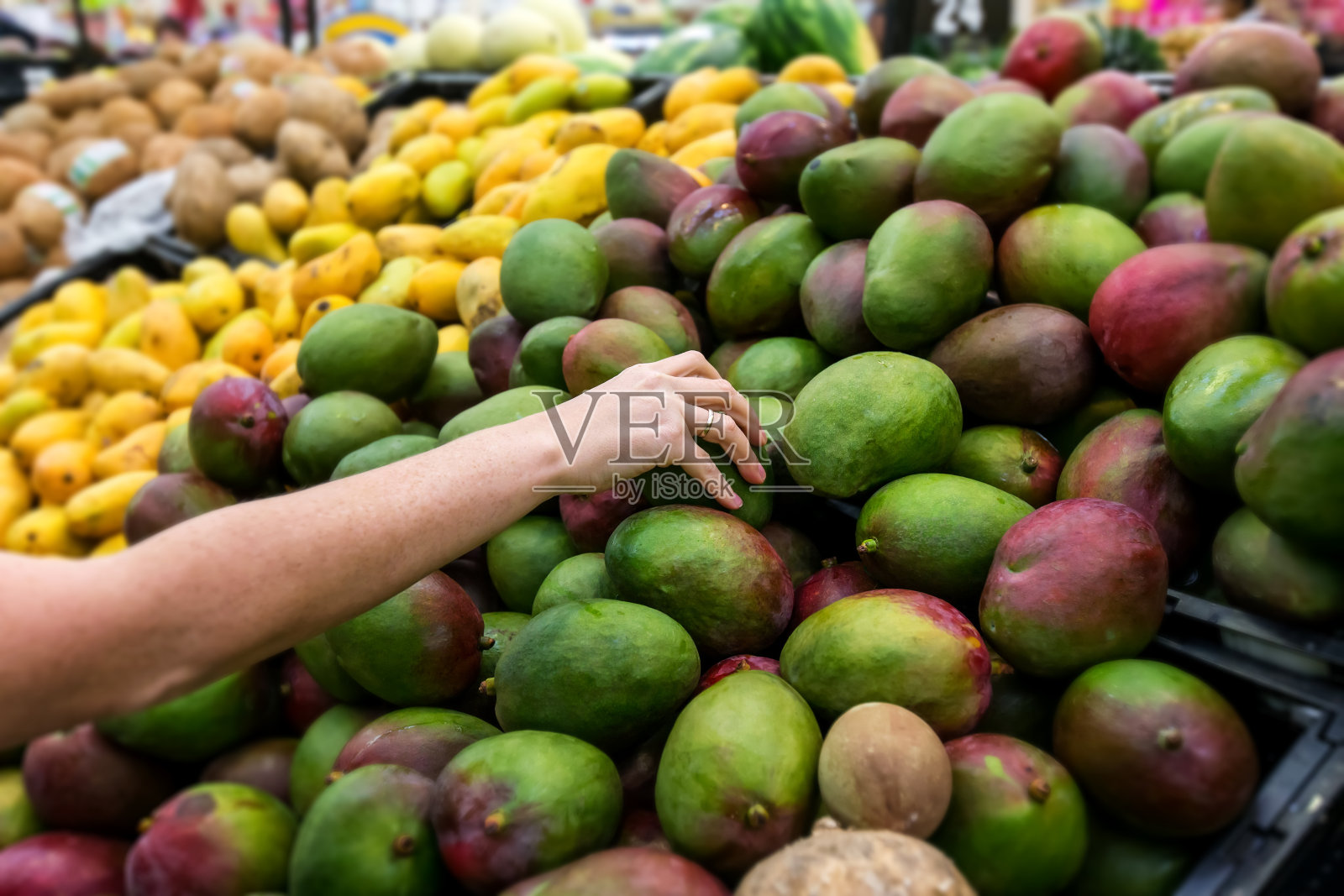 在市场上买新鲜芒果的女人照片摄影图片