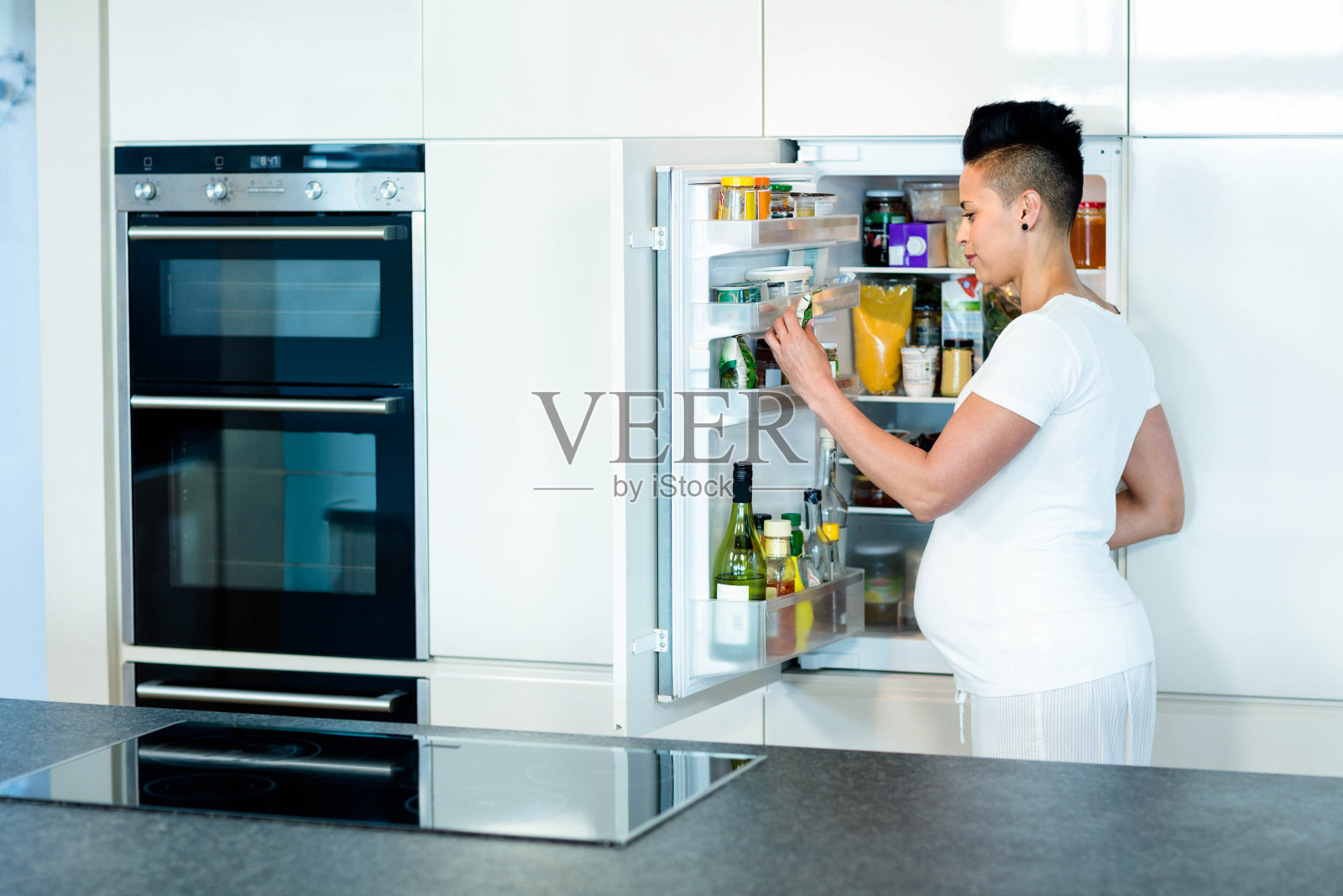 在冰箱里找食物的孕妇照片摄影图片