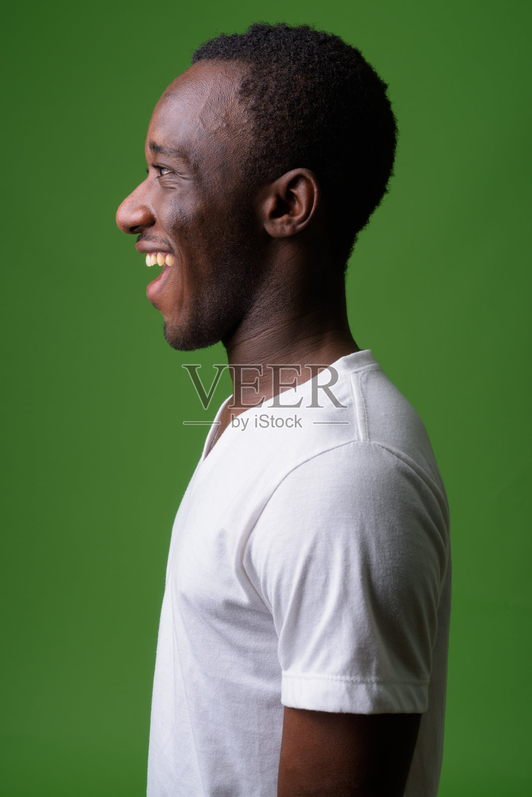 一名年轻的非洲男子穿着白色衬衫，背景是绿色照片摄影图片
