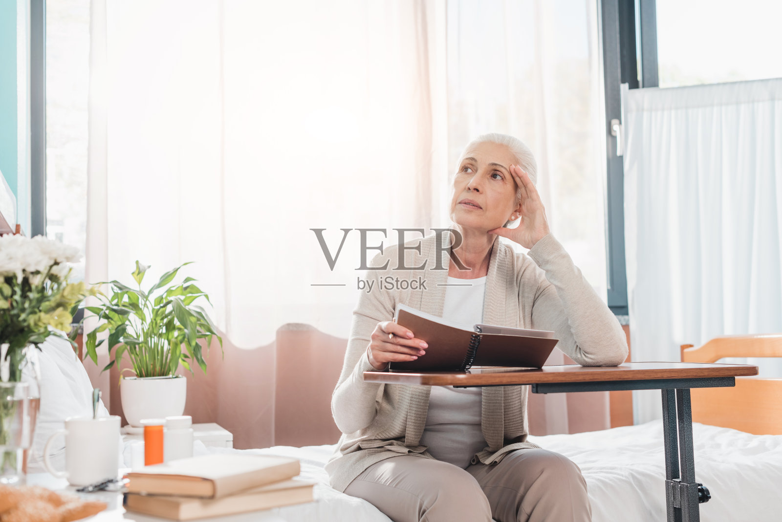 senior woman with notebook in hospital照片摄影图片