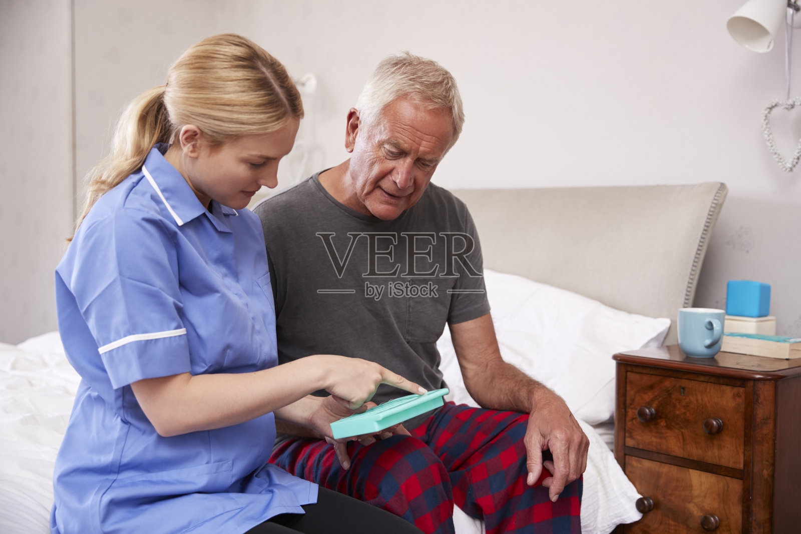 护士在家访中帮助老人安排药物治疗照片摄影图片