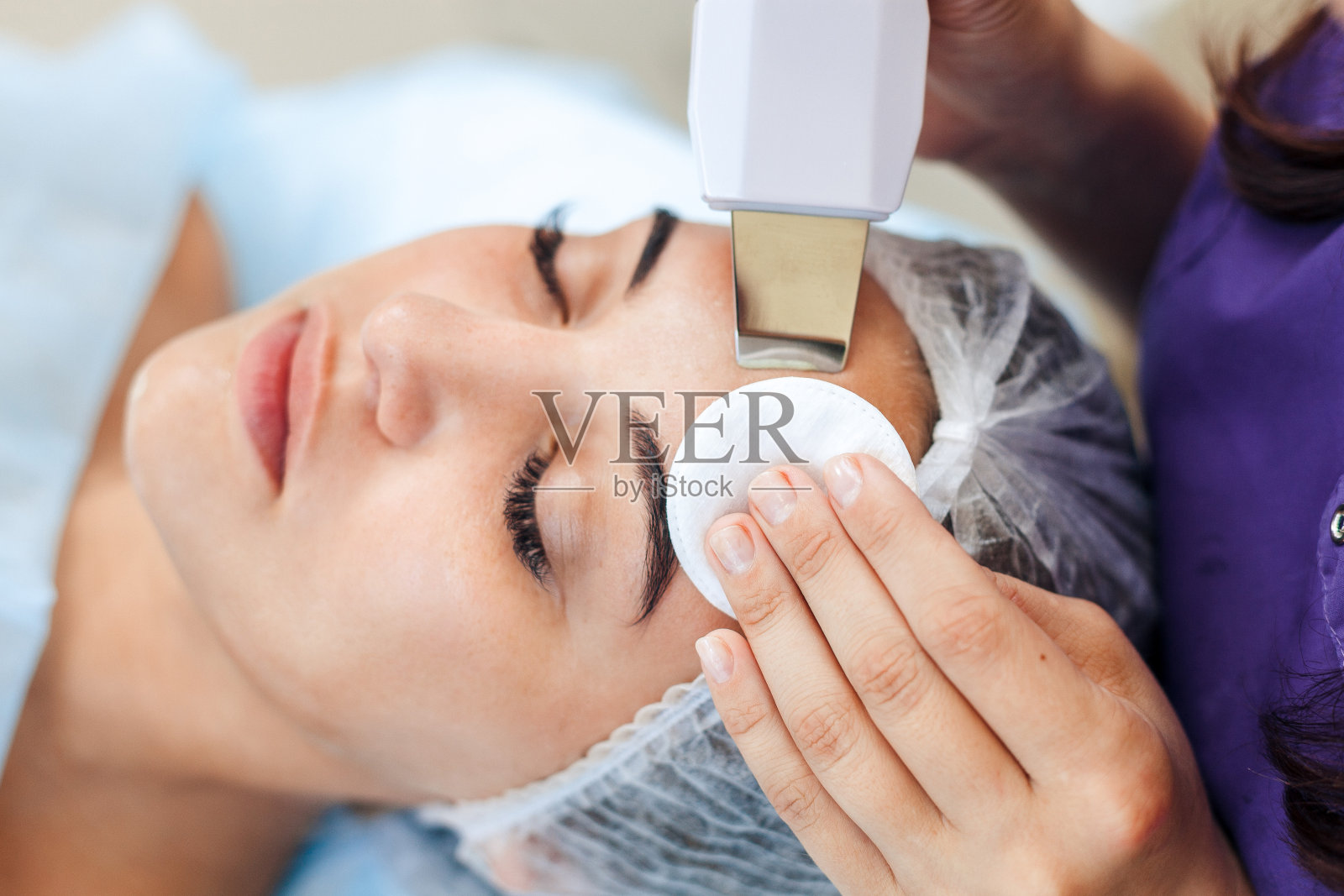 面部皮肤护理。女人在做面部超声波清洁照片摄影图片