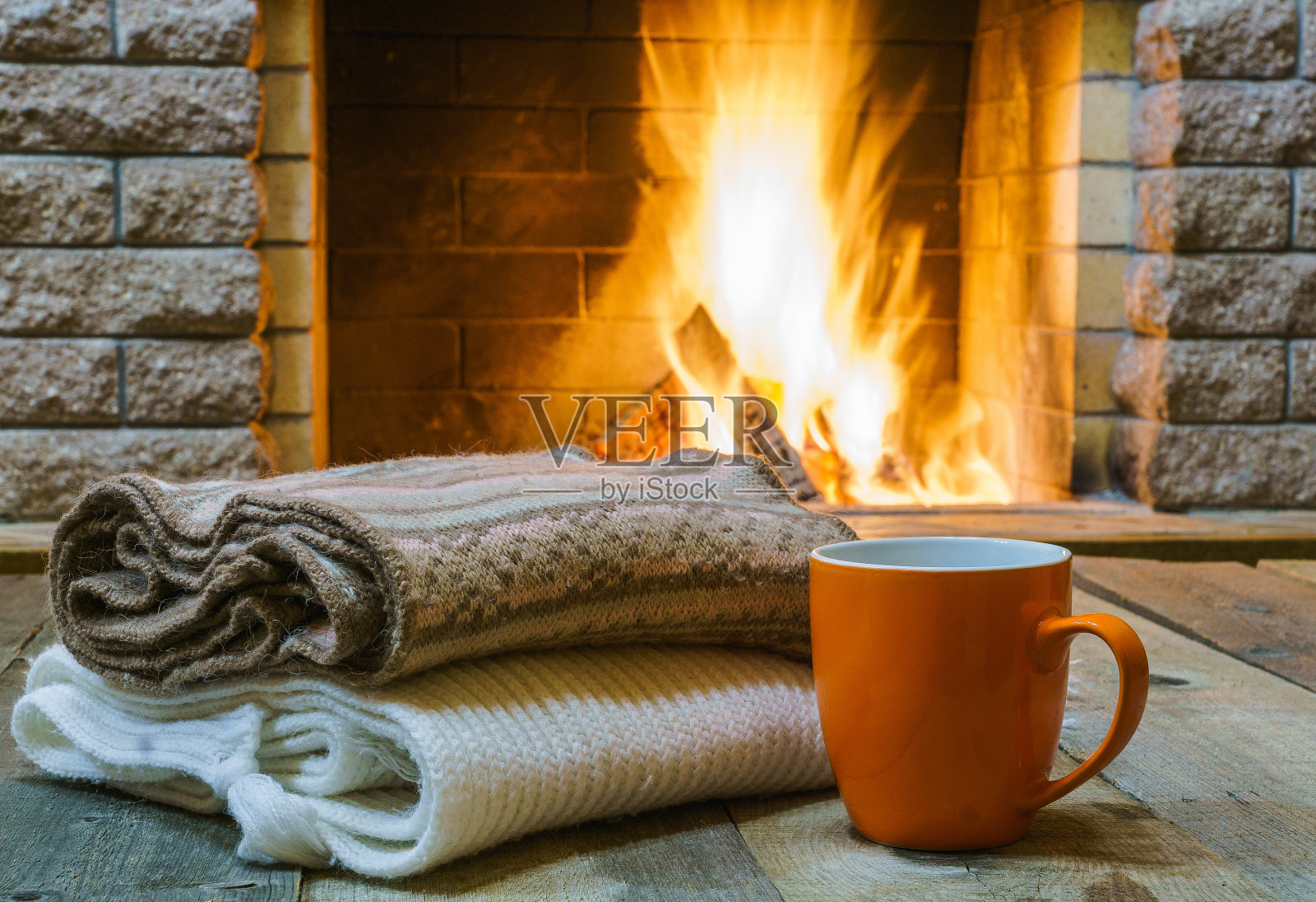 用来喝茶或咖啡的杯子，羊毛制品，放在舒适的壁炉旁。照片摄影图片