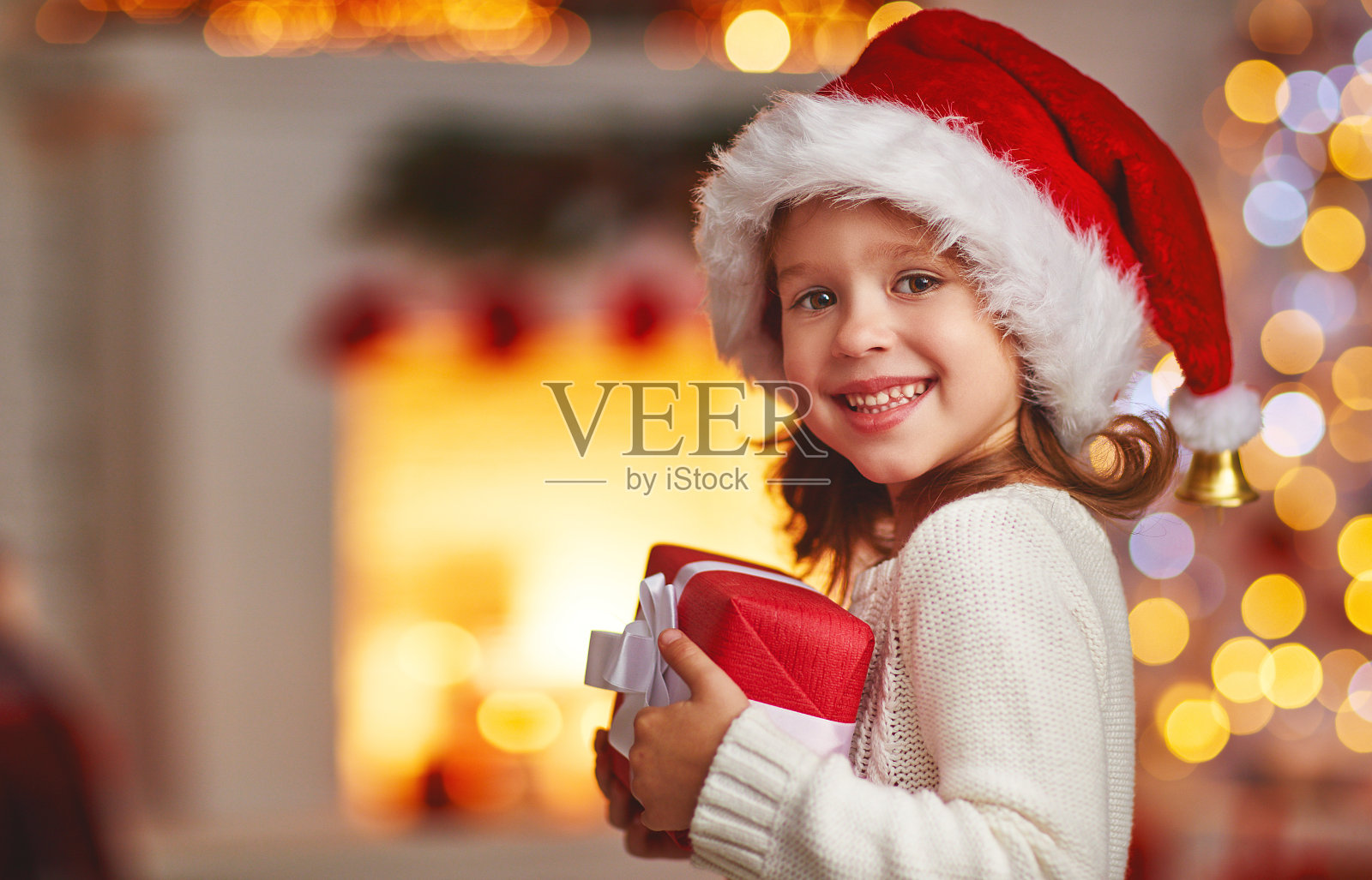 快乐欢笑的童女带着圣诞礼物在家照片摄影图片