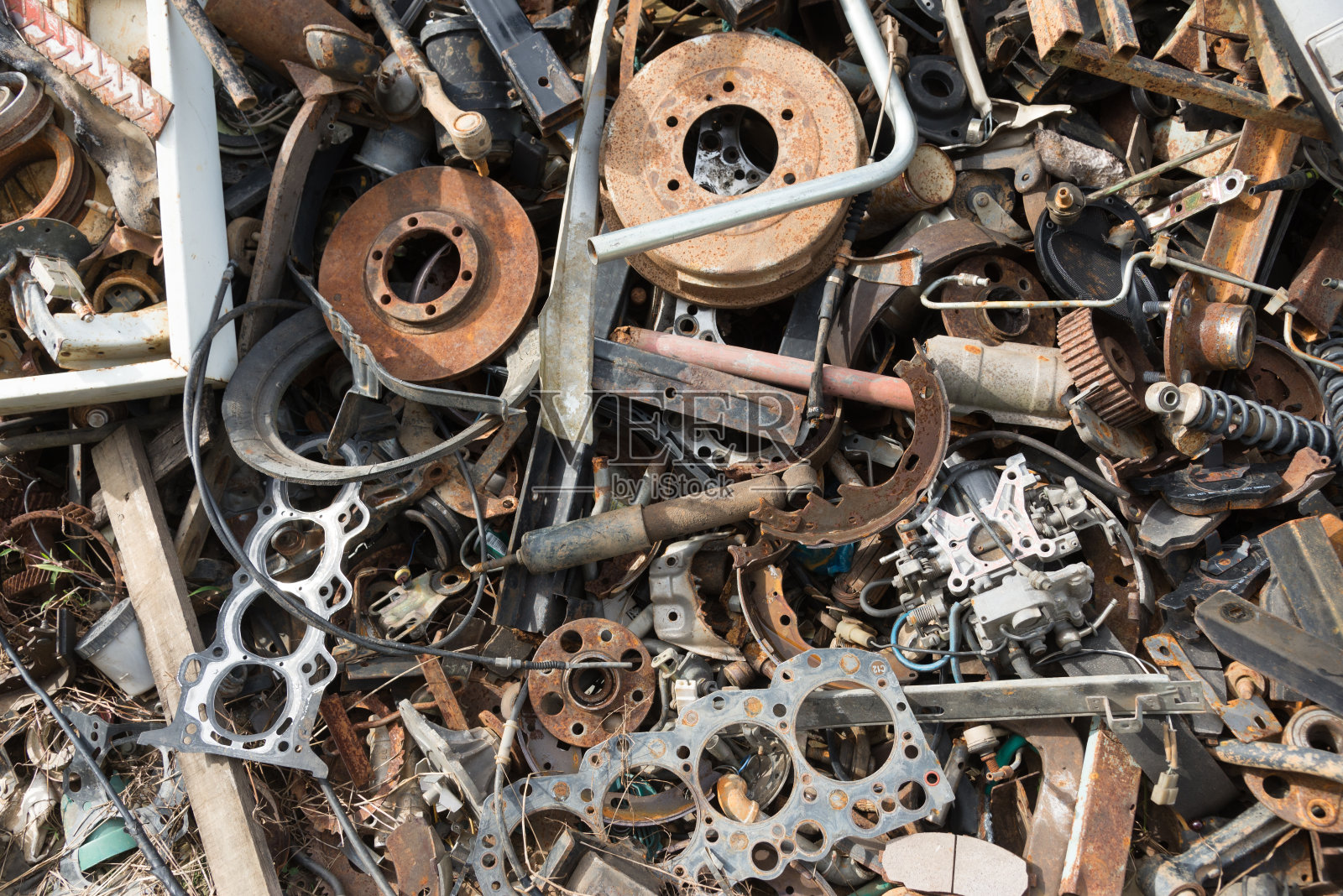 旧的生锈的汽车零件在汽车报废场。汽车回收。拆卸机械部件等待再利用或作为维修部件。照片摄影图片