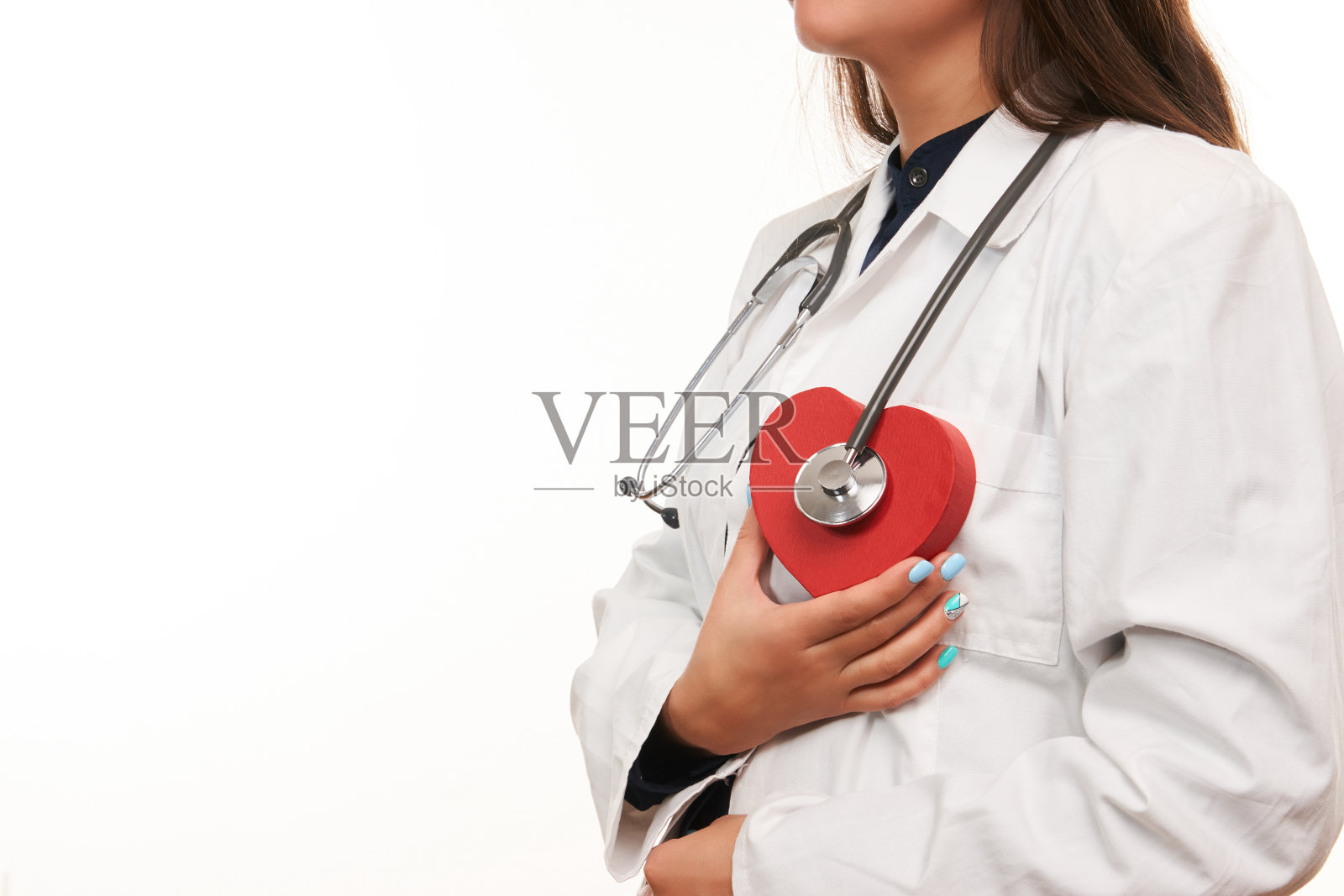 手持医用听诊器和红心的女医生照片摄影图片