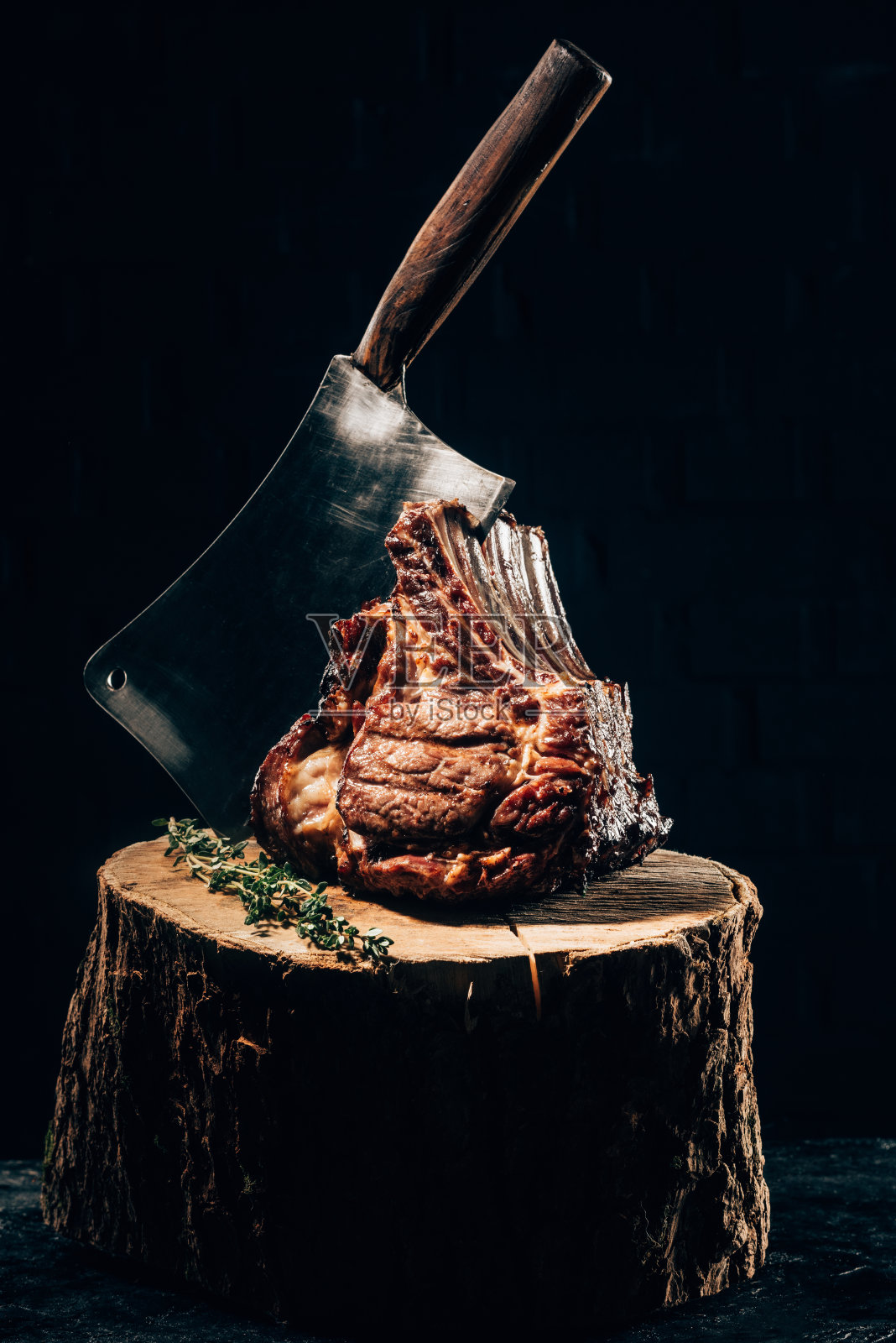 近距离观看美味的烤排骨与肉刀和迷迭香在木桩上照片摄影图片