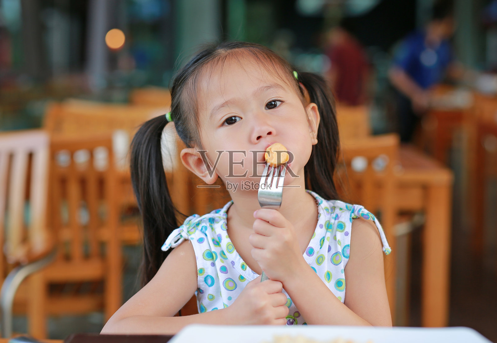 小女孩在餐厅吃香肠当早餐。照片摄影图片