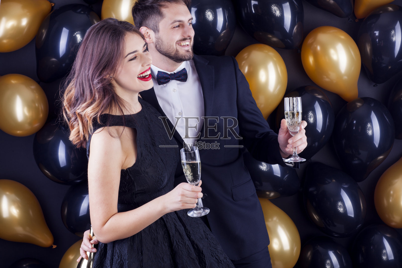 年轻夫妇用香槟庆祝新年前夜。照片摄影图片