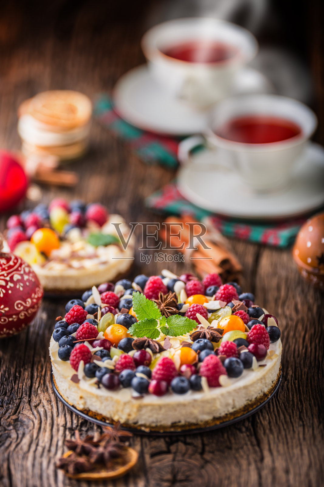 芝士蛋糕配新鲜水果浆果、草莓、覆盆子和八角。有圣诞装饰的圣诞奶酪蛋糕照片摄影图片