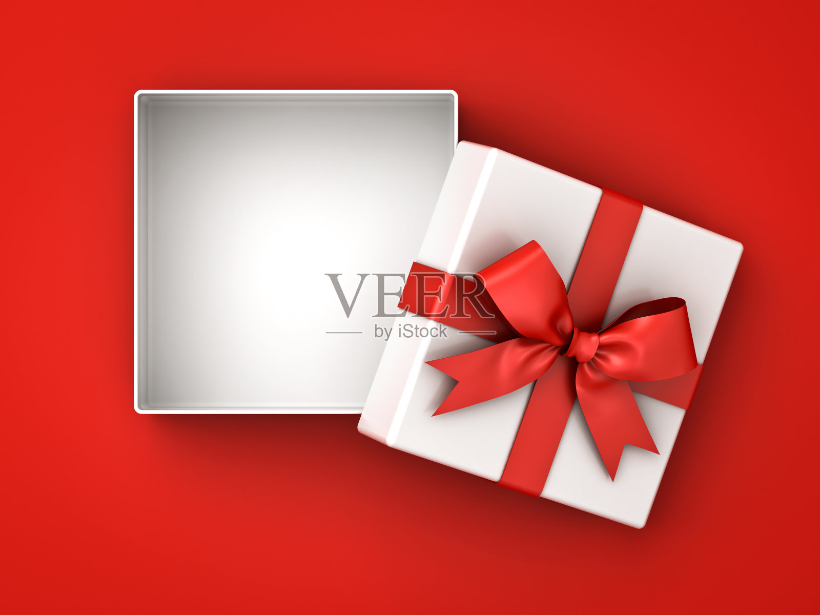 打开礼品盒，礼品盒用红色丝带蝴蝶结，盒子上的空白与红色背景上的阴影隔离照片摄影图片