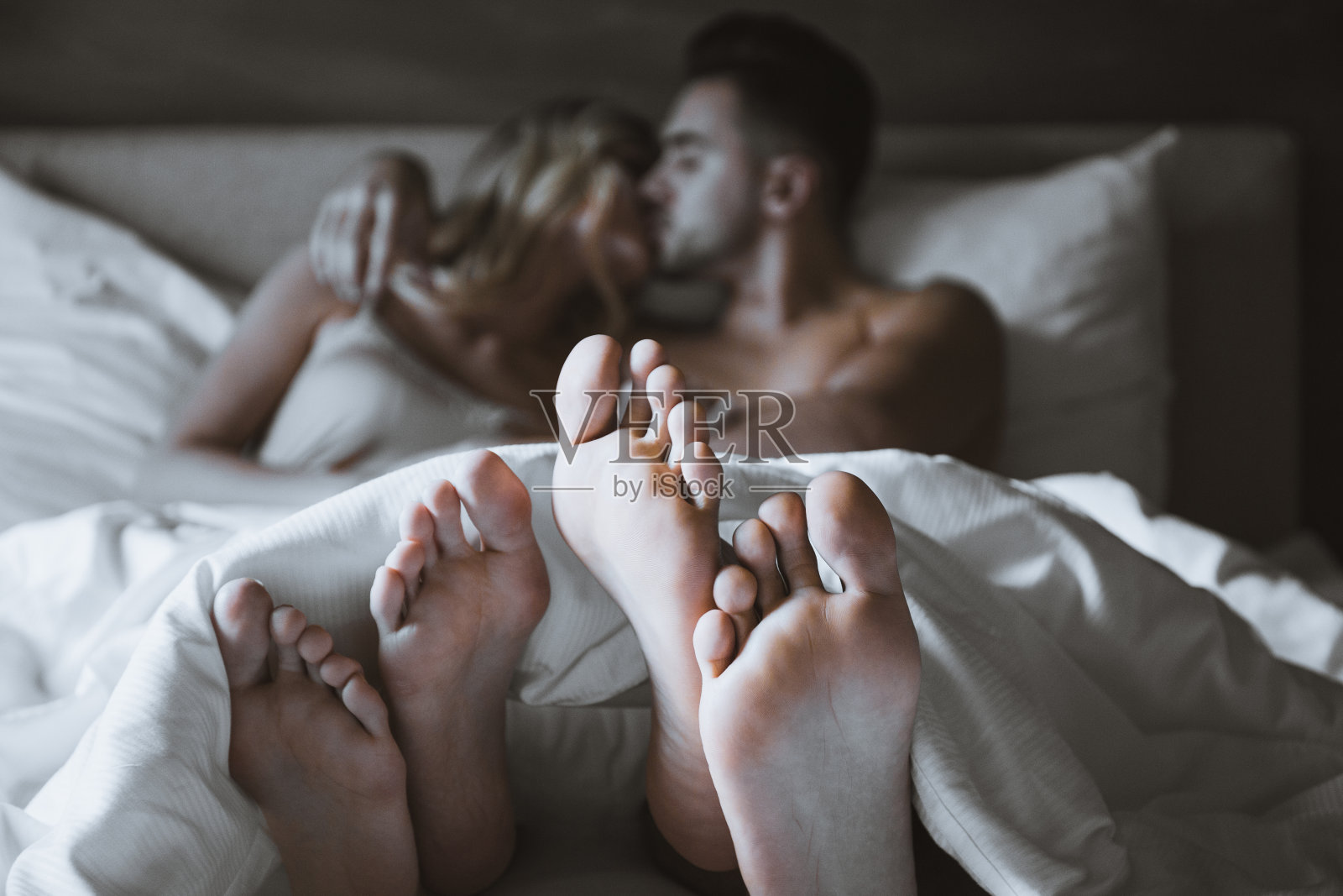 一对情侣躺在床上接吻照片摄影图片