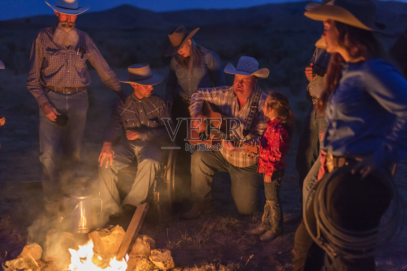 篝火歌唱与牛仔和女牛仔在晚上照片摄影图片
