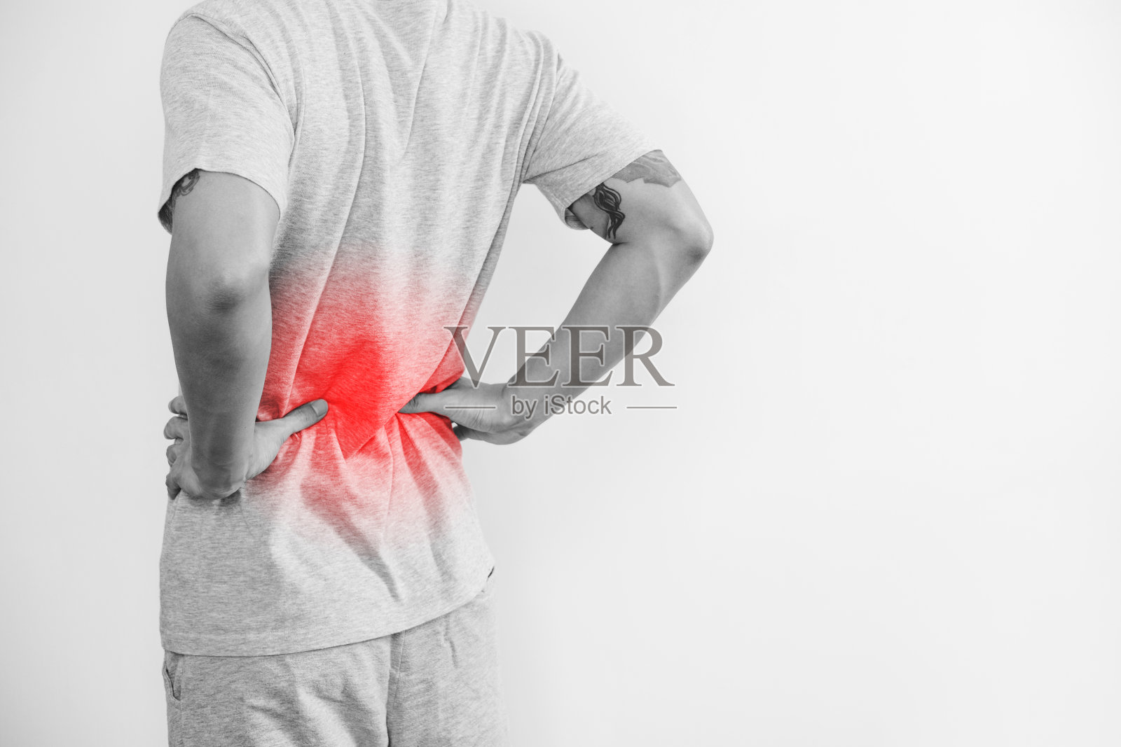 一个男人摸着他的背，上面有红色的高光。背部疼痛，背部疼痛和腰部疼痛，在白色背景与复制空间照片摄影图片