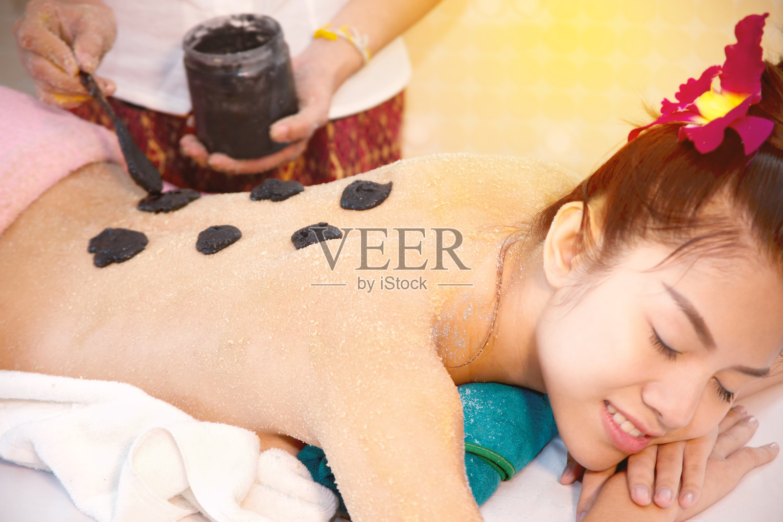 泰国美丽的女性放松与木炭盐疗法水疗按摩照片摄影图片