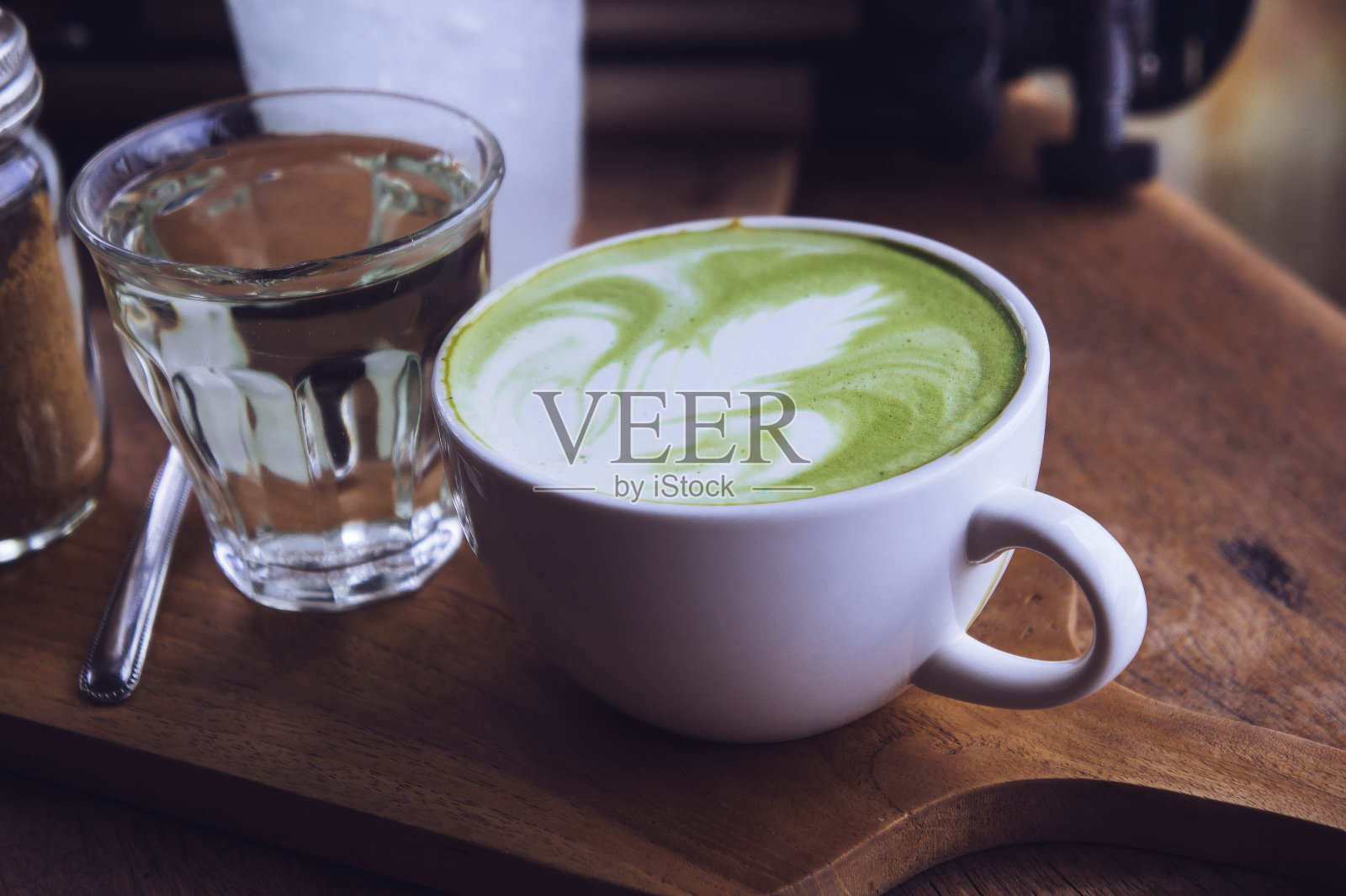 木桌上的绿茶热饮拿铁白杯，香气袭人，咖啡厅休闲时光照片摄影图片