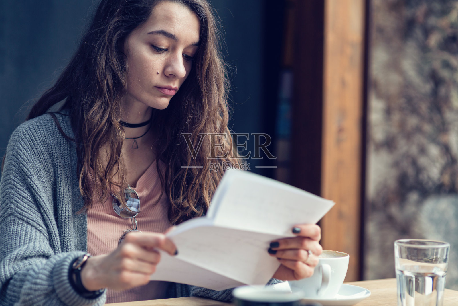 美丽的女性在她的咖啡休息时间读纸质信照片摄影图片