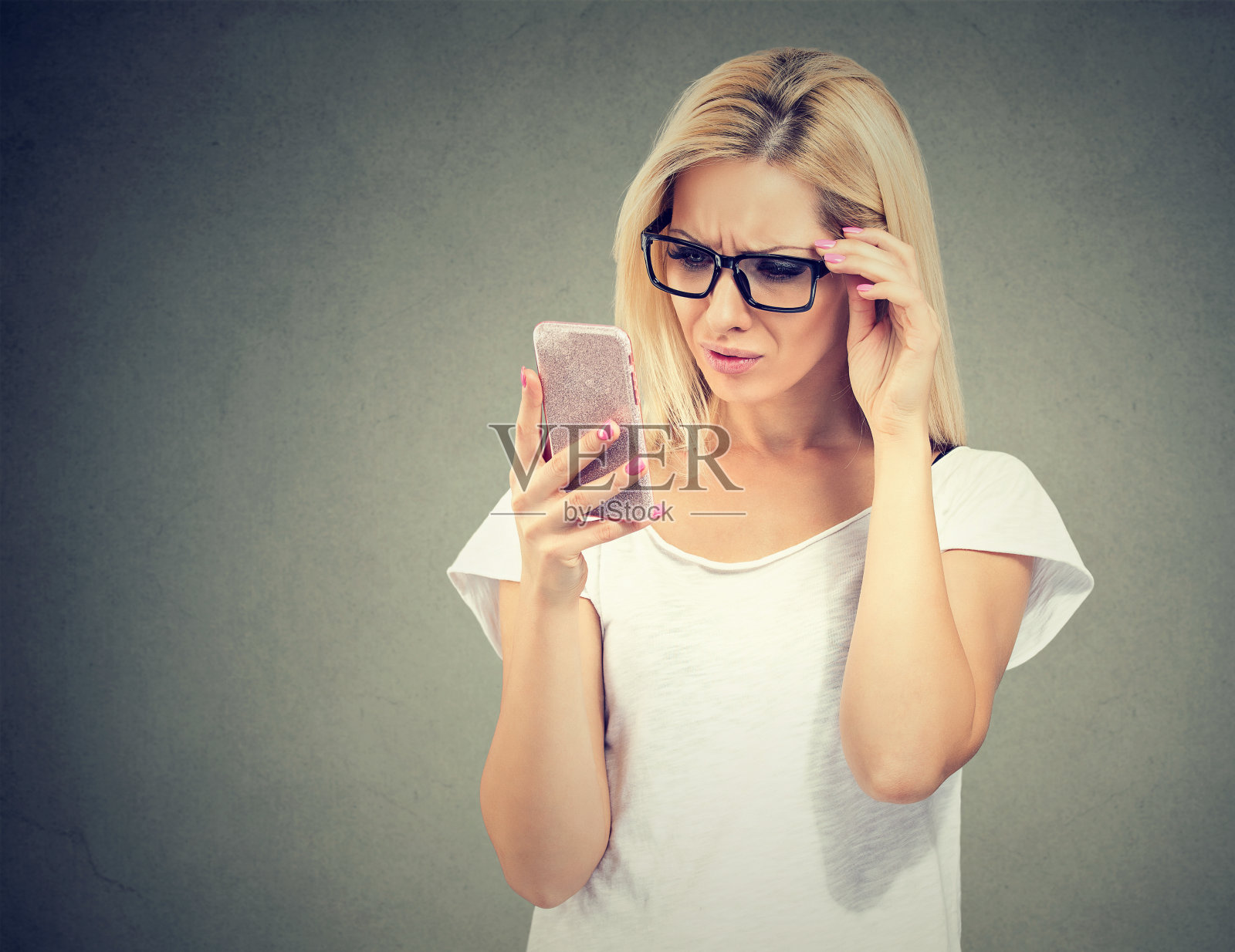 心烦意乱的女人戴着眼镜看她的智能手机与挫折照片摄影图片