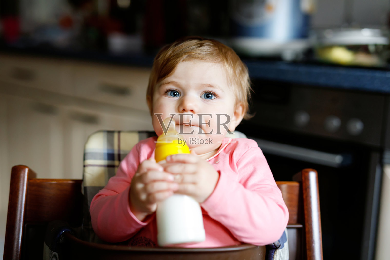 可爱可爱的初生女婴抱着奶瓶喝配方奶照片摄影图片