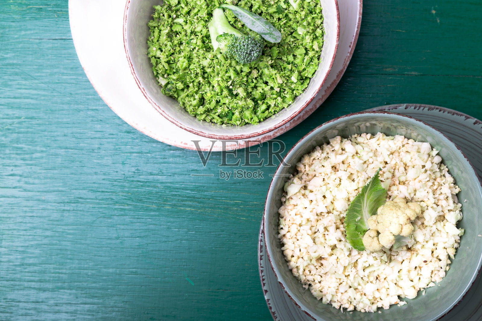 花椰菜米饭和花椰菜米饭在碗上的绿色背景。前视图。开销。副本的空间。粉碎。照片摄影图片