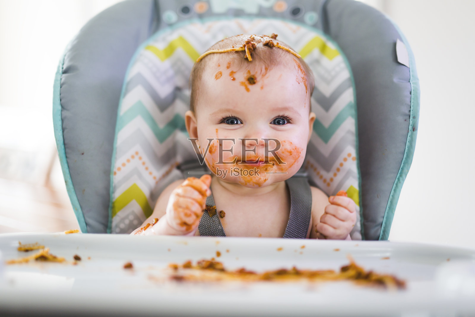 小婴儿在吃她的晚餐，弄得一团糟照片摄影图片