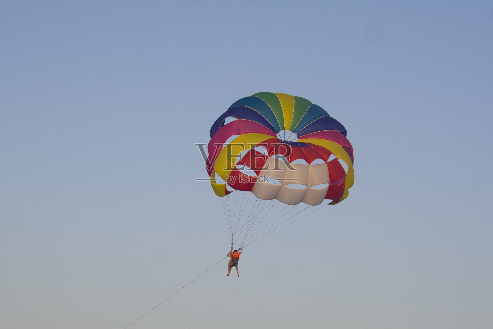 人在一个圆形的明亮的降落伞上飞行照片摄影图片