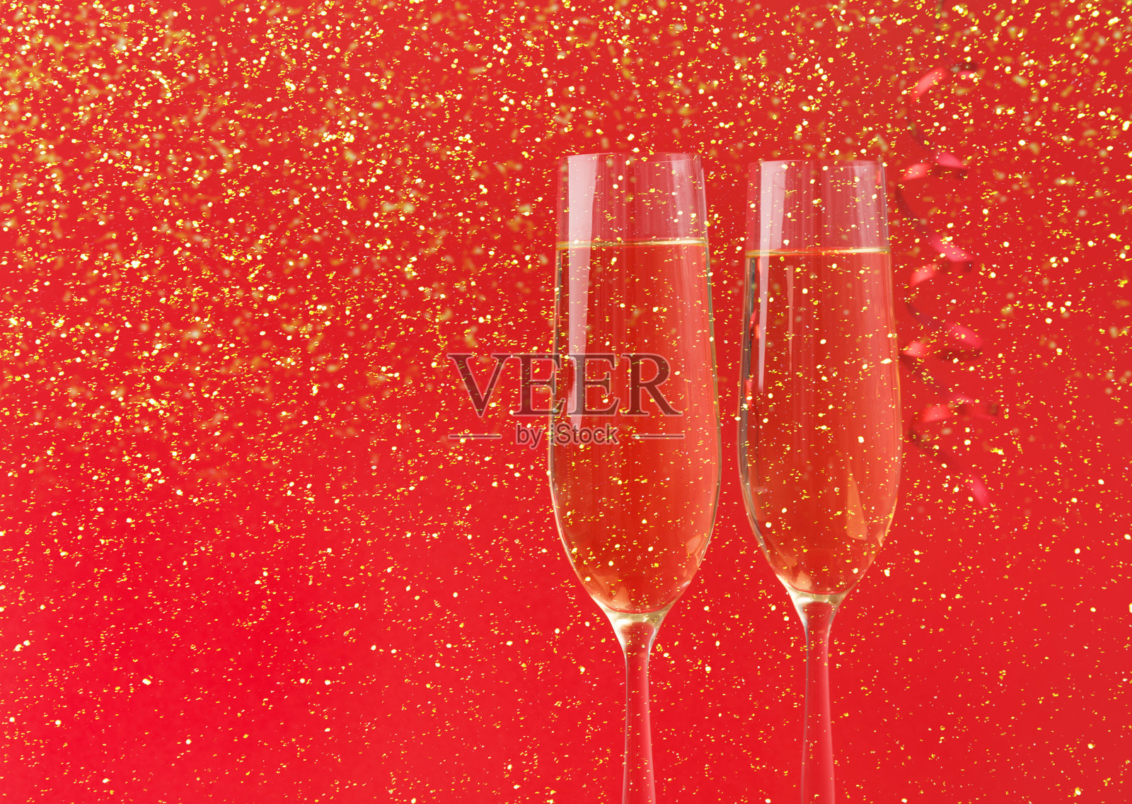红色假日背景上的香槟酒杯照片摄影图片