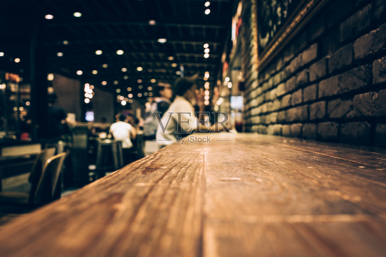 模糊的木条桌子在夜间咖啡馆/选择性焦点照片摄影图片