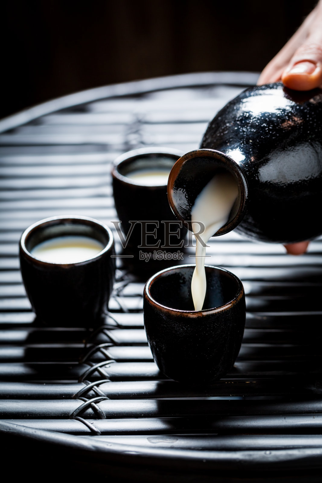 在黑色的桌子上的黑色陶瓷美味的清酒特写照片摄影图片