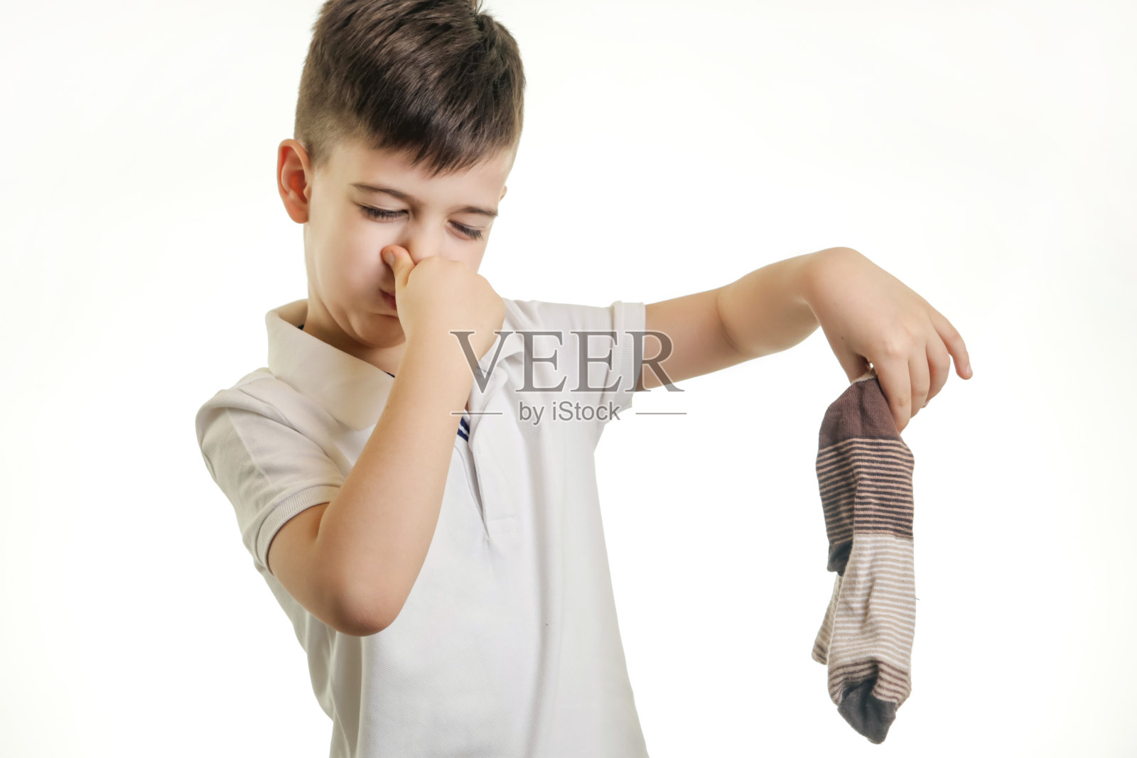 摄影棚拍摄的小男孩拿着臭袜子照片摄影图片