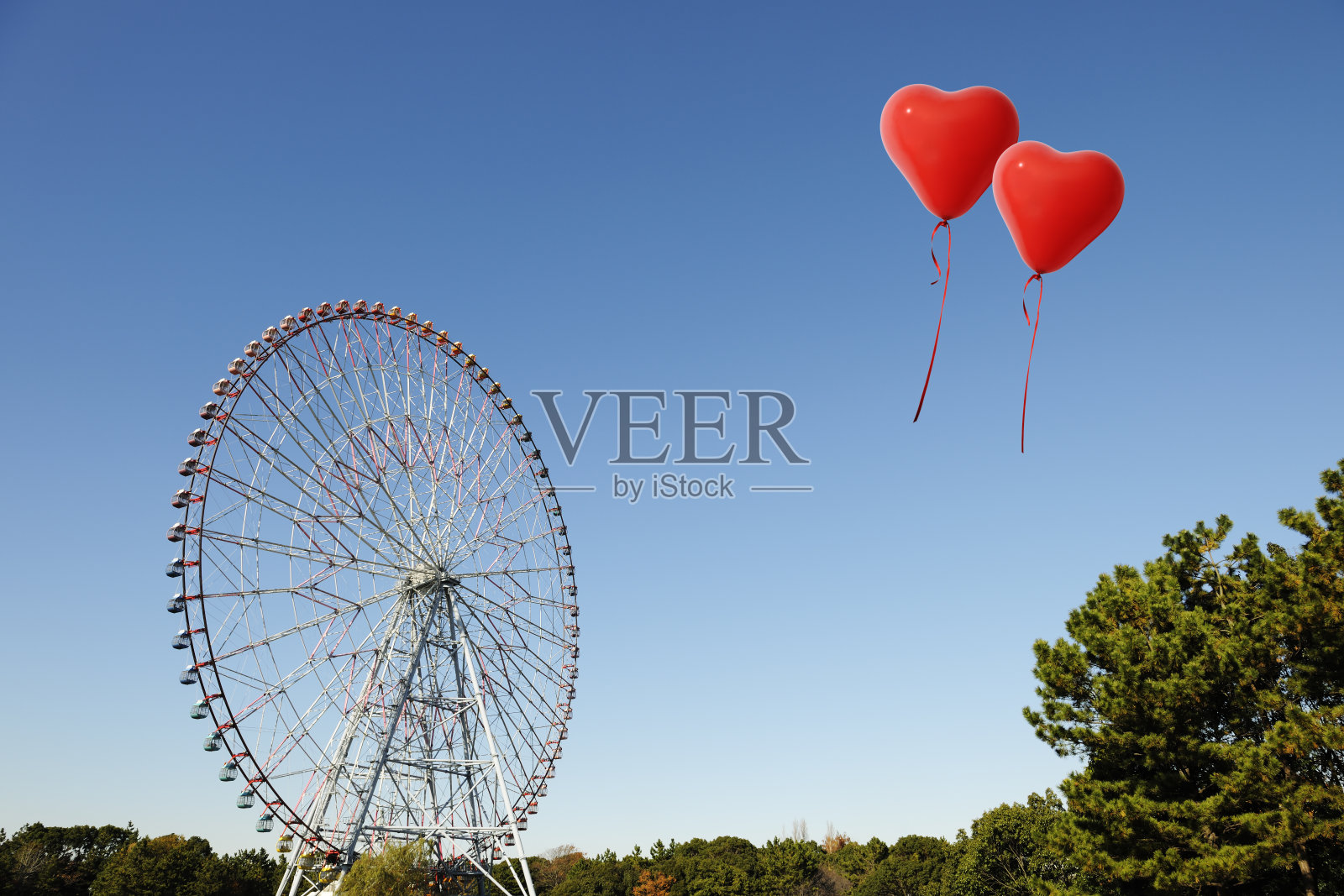 漂浮在空中的红色心形气球和巨大的摩天轮照片摄影图片