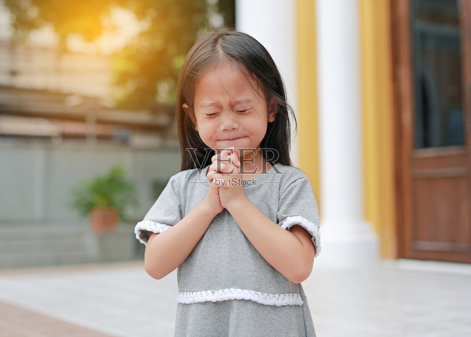 小女孩交叉着双手祈祷照片摄影图片_ID:310942101-Veer图库
