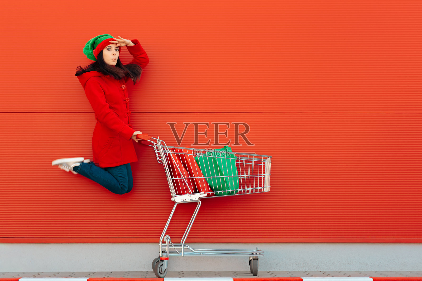 快乐的女人与购物车准备圣诞销售照片摄影图片