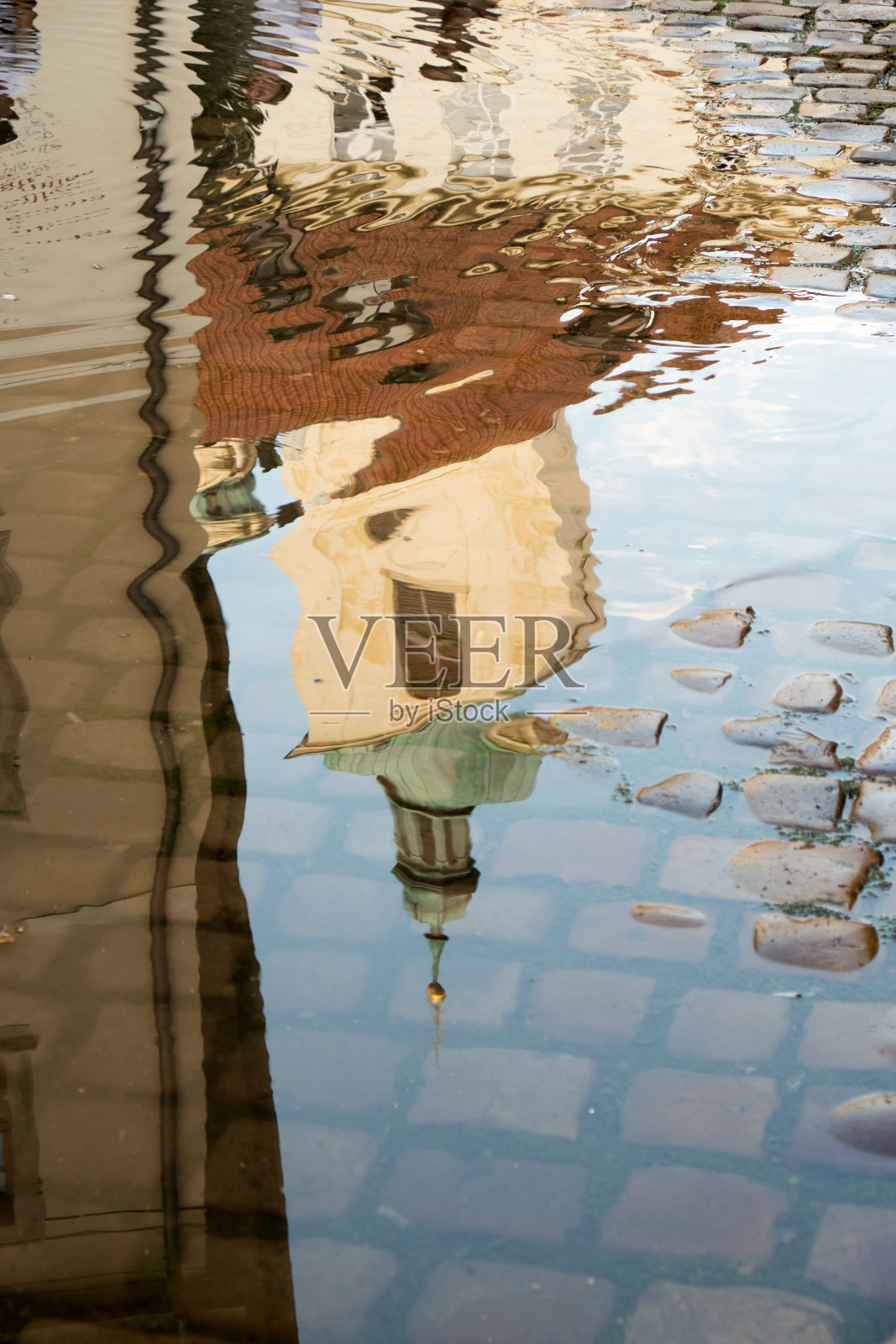 圣詹姆斯大教堂的倒影(Kostel svateho Jakuba Vetsiho)在一个水坑上的鹅卵石街道在布拉格捷克共和国，布拉格老城。水池中教堂的倒影。照片摄影图片