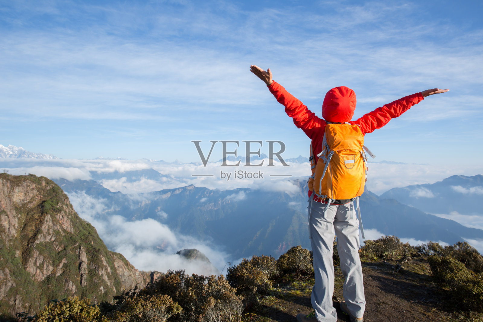 幸福成功的女性徒步旅行者站在山峰峭壁边缘照片摄影图片