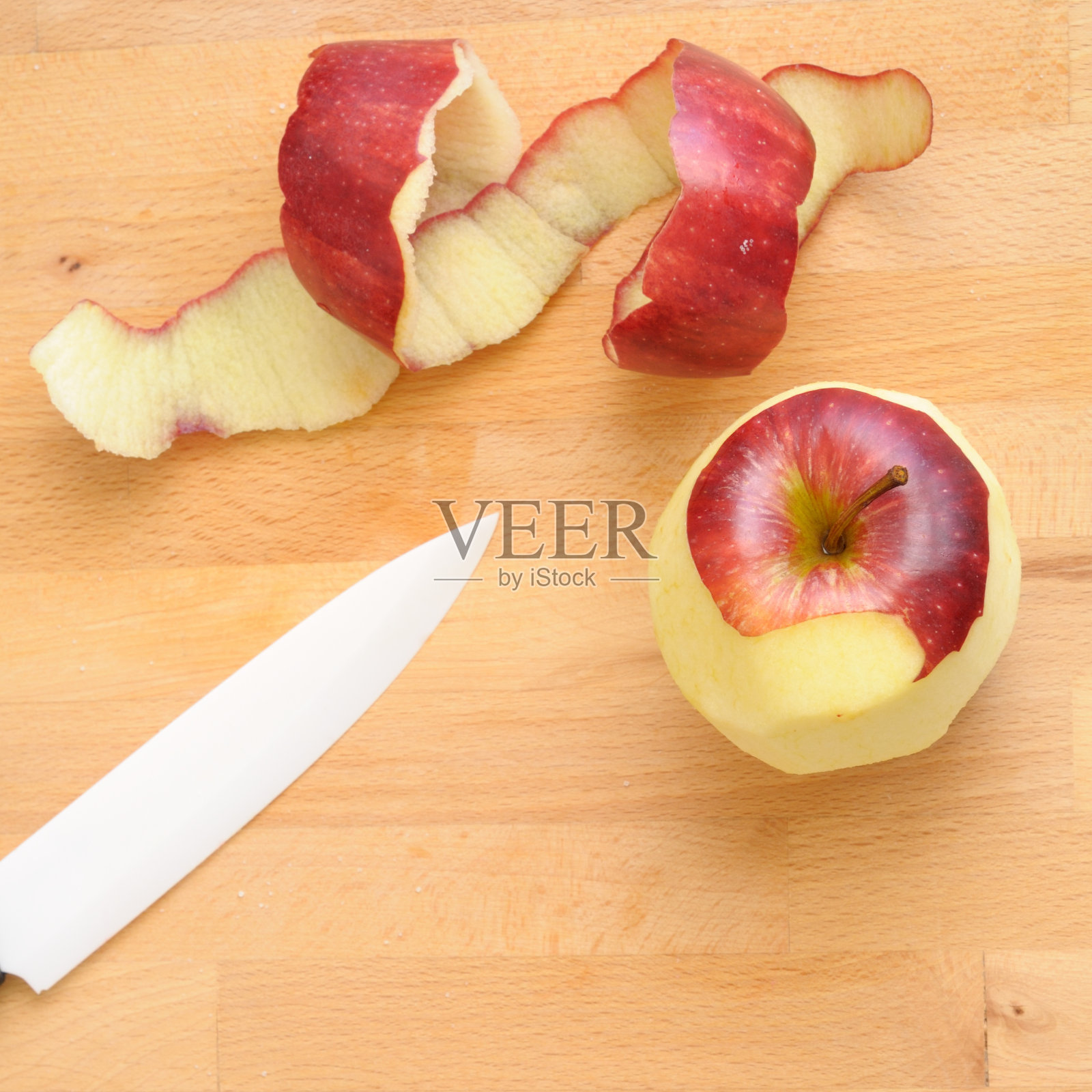 白色陶瓷刀削红苹果，方形照片摄影图片
