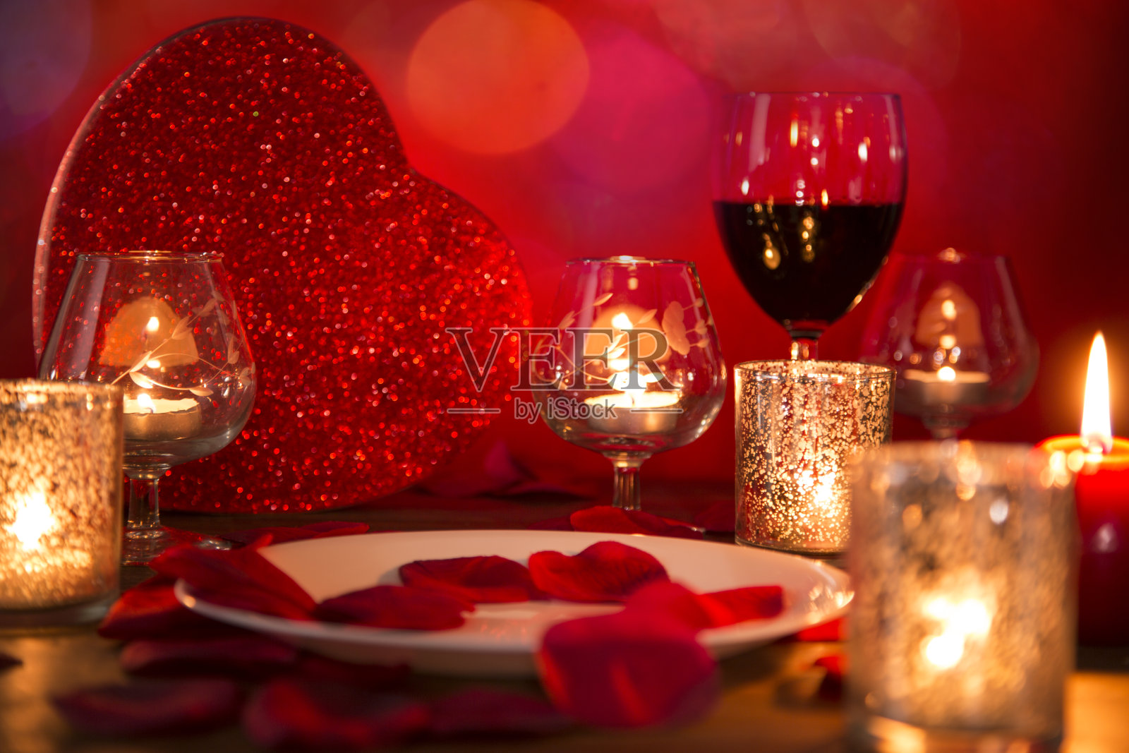 情人节浪漫的烛光晚餐，贴心的礼物和美酒。照片摄影图片