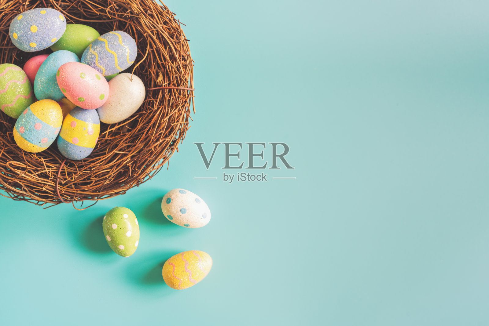 色彩缤纷的复活节彩蛋在巢上，色彩柔和的背景与空间。照片摄影图片