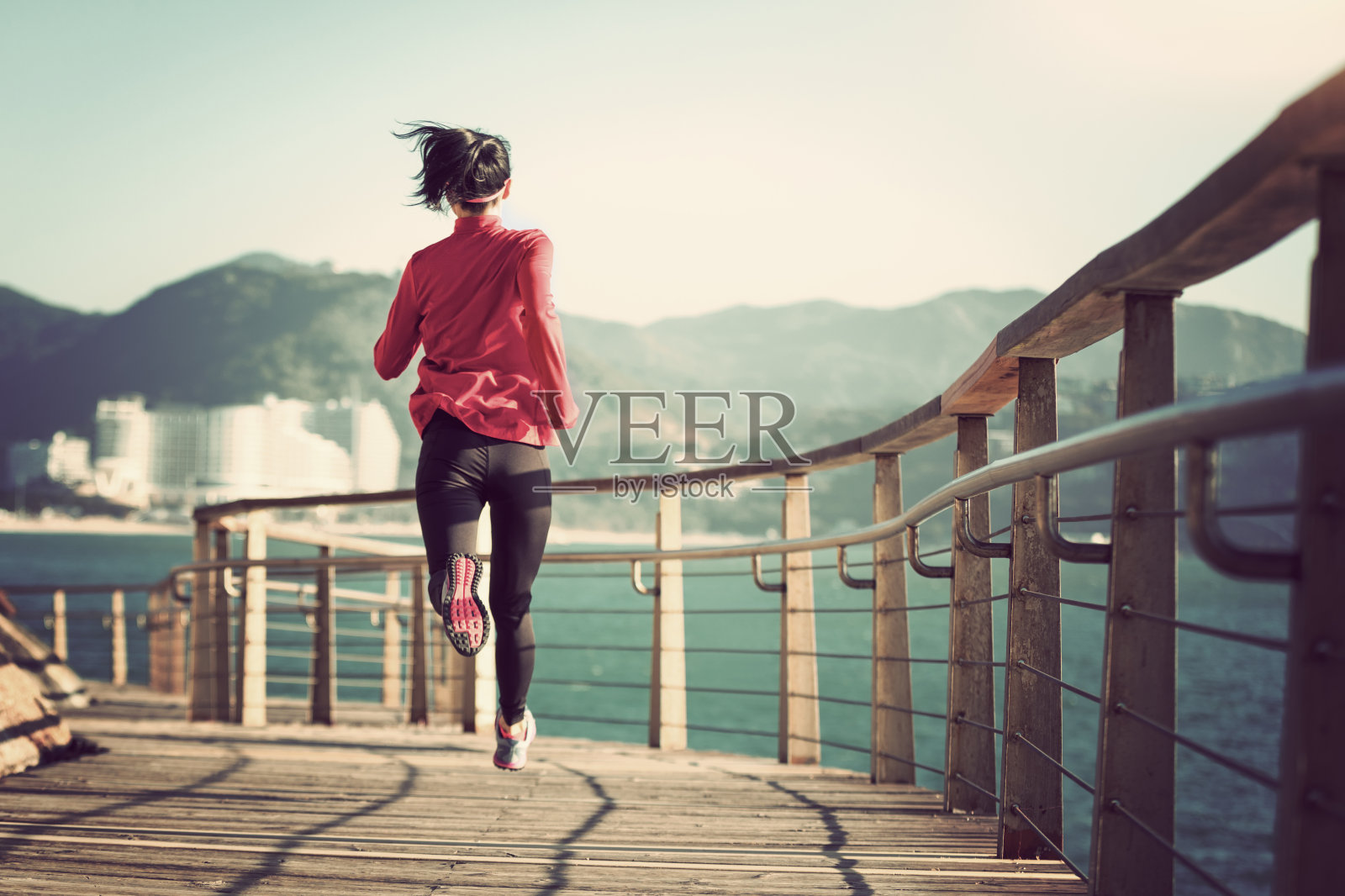 运动健身女性跑步在海滨木板路照片摄影图片
