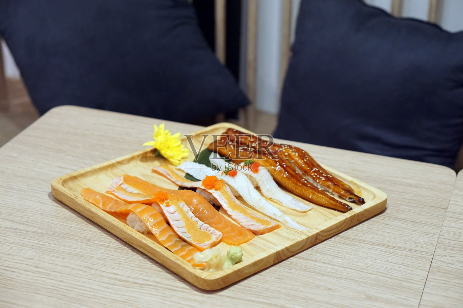 木桌背景上有寿司手握寿司、新鲜鲑鱼和三文鱼寿司(烧)、鳗鱼(烤鳗鱼)、恩加瓦(鱼鳍)。照片摄影图片
