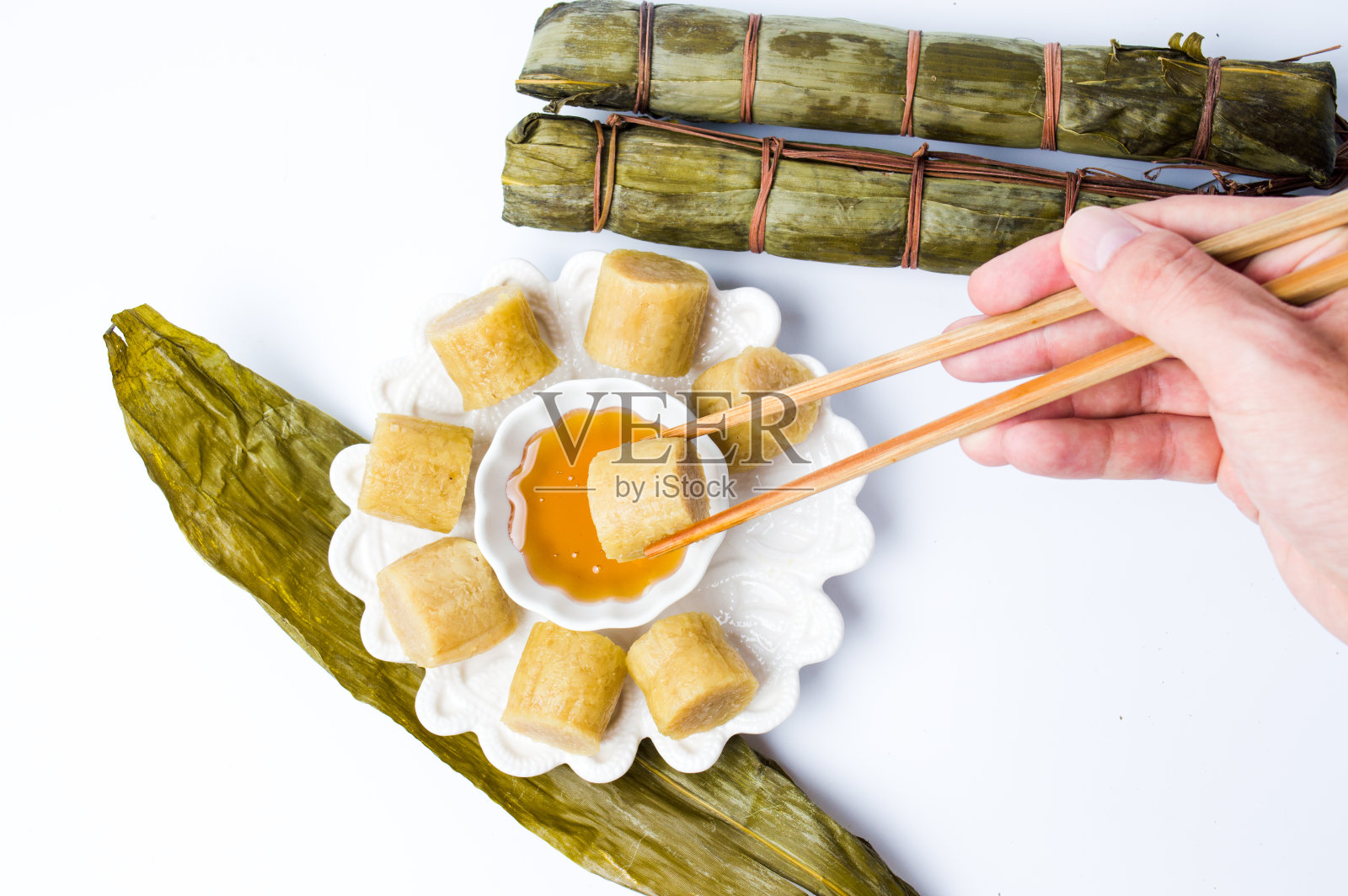 筷子从餐桌上取下一片端午节的粽子照片摄影图片