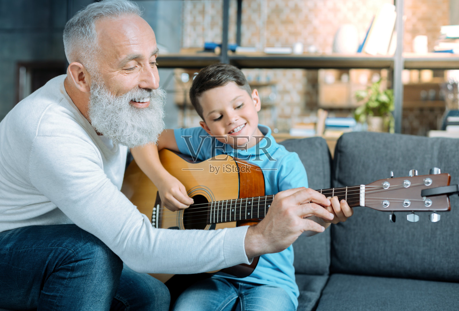 慈爱的爷爷教孩子弹吉他照片摄影图片