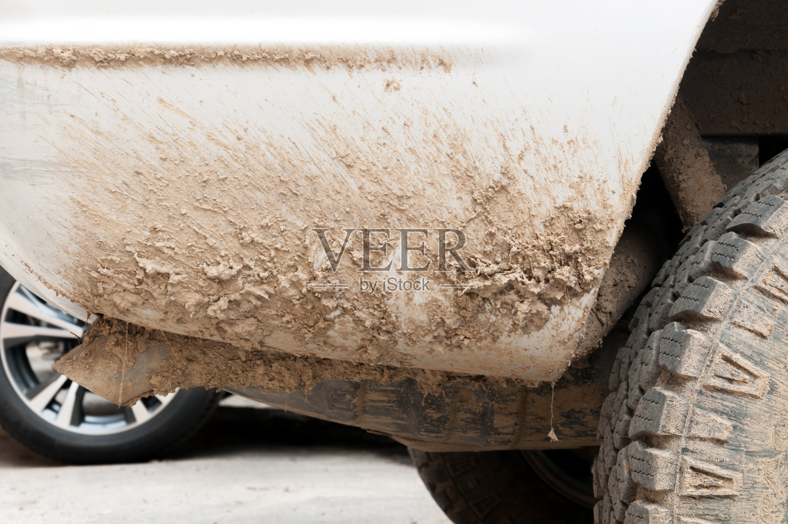 极其肮脏的白色公路4x4汽车与大量的泥土，泥和灰尘从后方驾驶通过潮湿的地面和自然近距离照片摄影图片