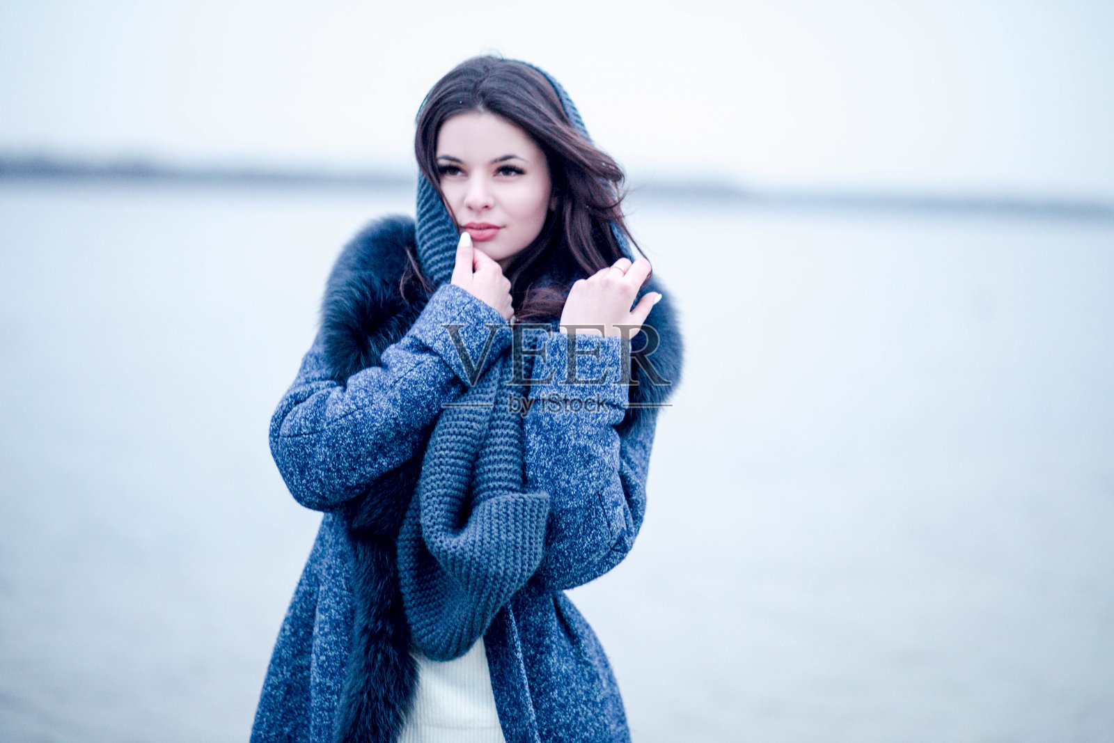 可爱快乐的年轻女子在冬天穿着温暖的外套照片摄影图片