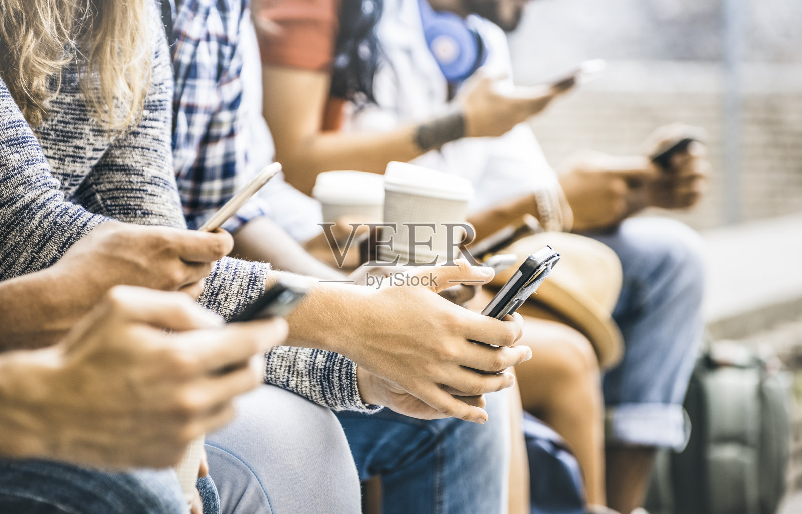 多文化的朋友群使用智能手机与咖啡在大学休息-人们的手沉迷于移动智能手机-技术概念与连接的时尚千禧一代-滤镜图像照片摄影图片