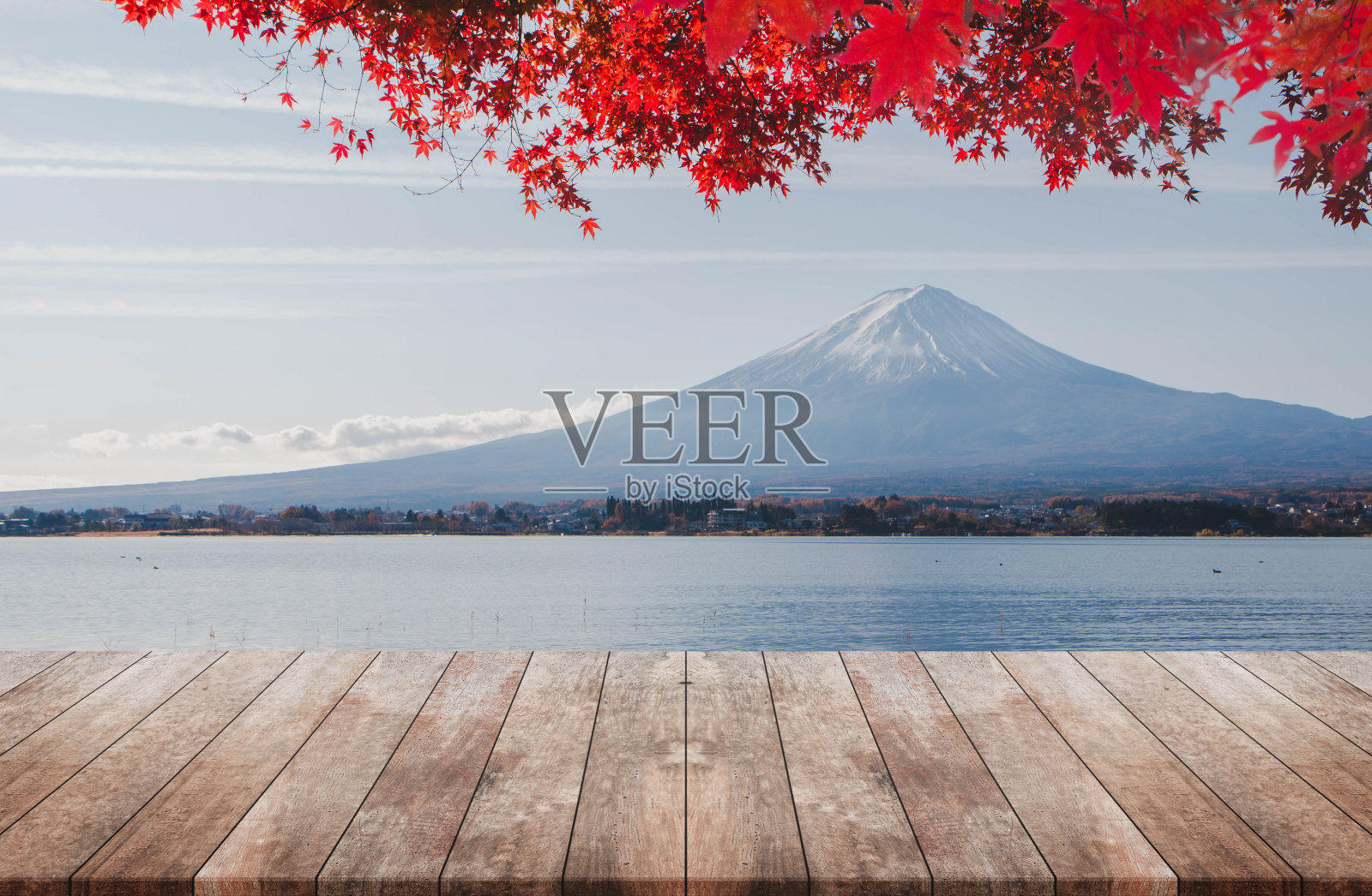 木质桌面在早晨富士山与秋天的红色枫叶的背景-可以用来展示或蒙太奇您的产品。照片摄影图片