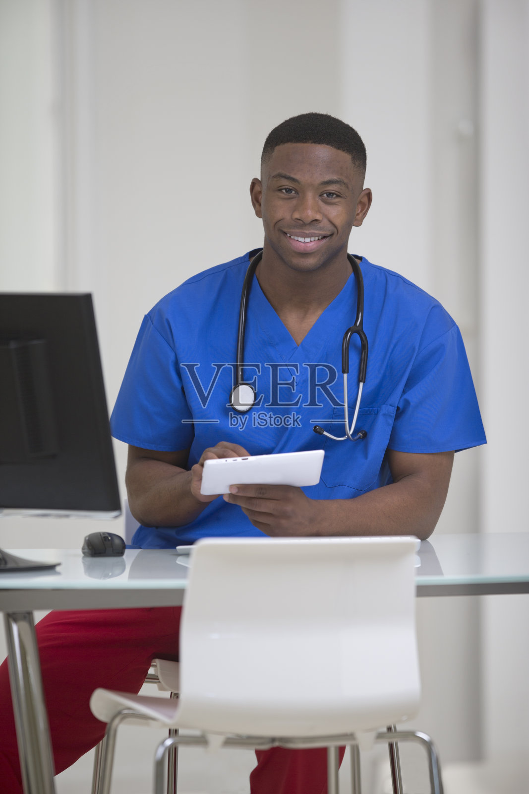非裔美国医疗工作者在他的办公桌前照片摄影图片