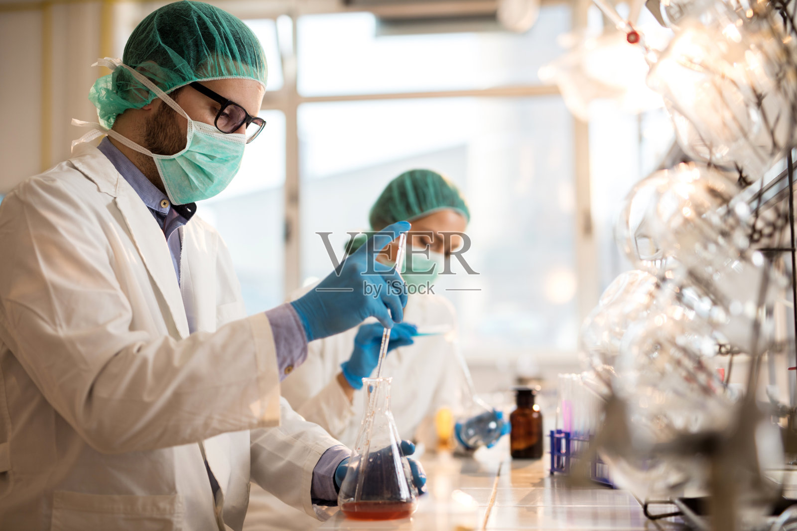 男性化学家在进行科学实验时处理医学样本。照片摄影图片